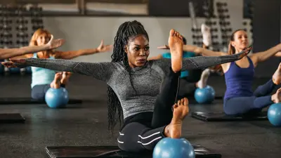 Multiple women doing exercises on the floor of a gym